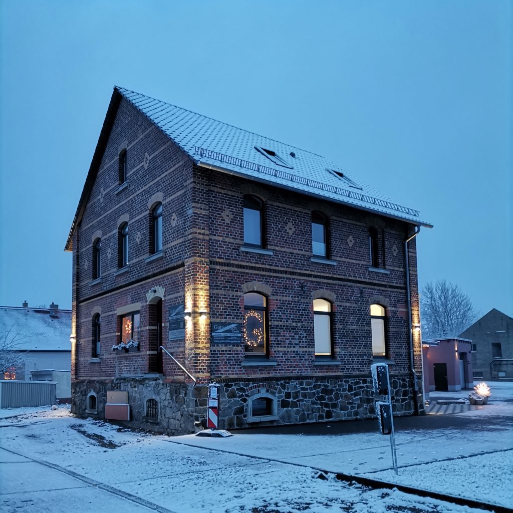 Bürogebäude in Kühren weihnachtlich beleuchtet und mit etwas Schnee berieselt
